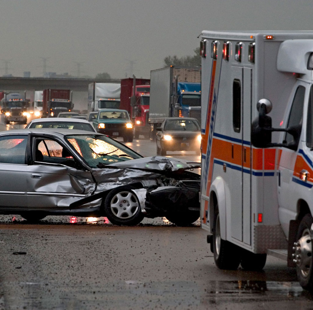 Image of car crash with ambulance and EMTs used to illustrate the importance of the TZD National Strategy