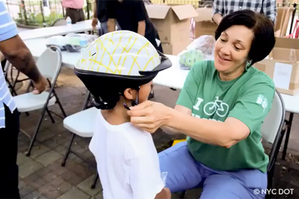 fitting a bicycle helmet on a boy @NYCDOT